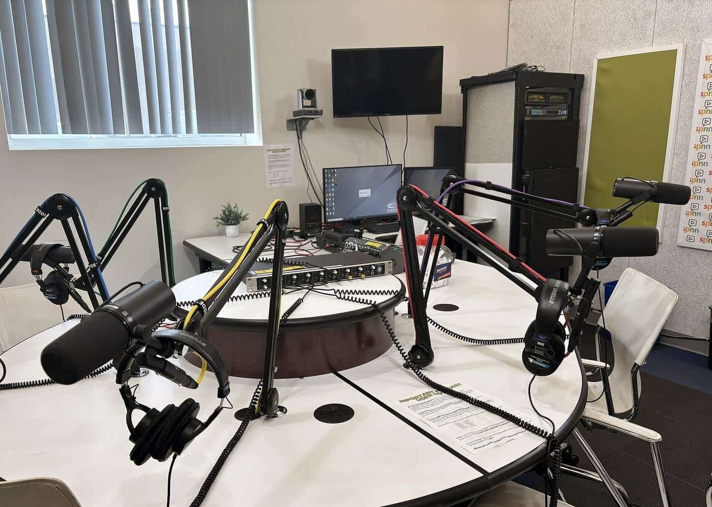 Microphones set up on a desk in a podcast studio