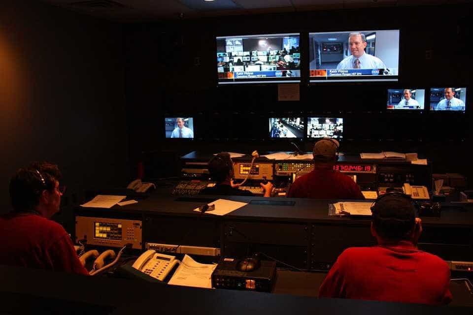 Producers working at screens and consoles in a television studio control room