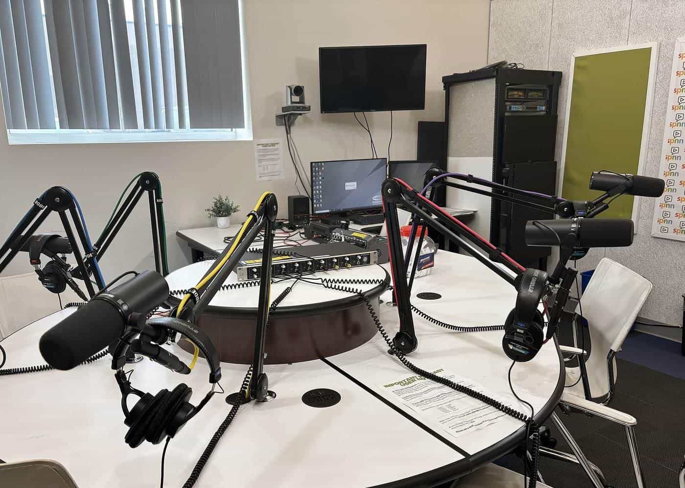 Microphones set up on a desk in a podcast studio