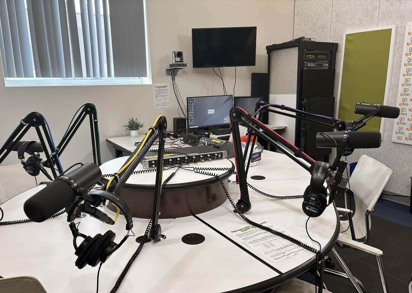 Microphones set up on a desk in a podcast studio